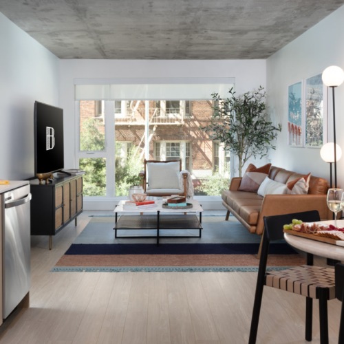 Modern apartment kitchen with stainless steel appliances and quartz countertops.