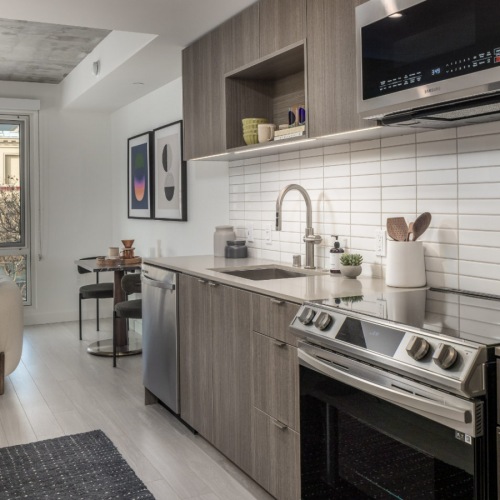 Modern apartment kitchen with stainless steel appliances and quartz countertops