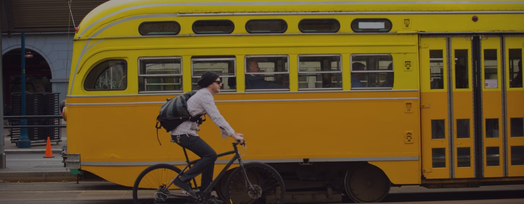 lifestyle image of a person riding their bicycle in front of passing metro bus